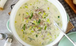 Cremige Lauchsuppe mit Hackfleisch in einem Topf, garniert mit Lauchringen.