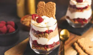Spekulatius-Himbeer-Dessert im Glas mit Sahne und frischen Himbeeren, garniert mit Spekulatius.