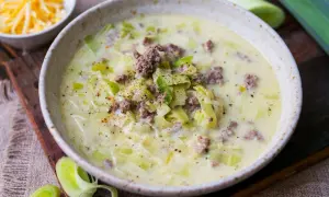 Cremige Lauchsuppe mit Hackfleisch und Käse, garniert mit Pfeffer.