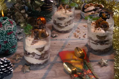 Festliche Desserts im Glas mit Bananen und Sahne, dekoriert mit Minze und Schokolade.