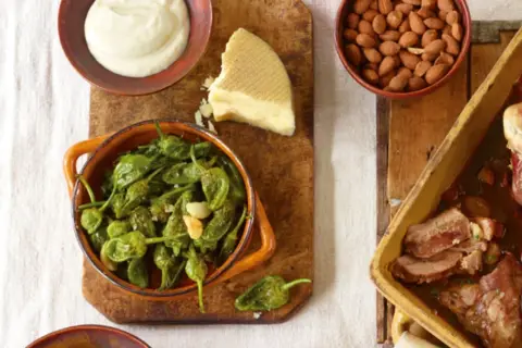 Tapas-Gerichte: Gebratene grüne Paprika, Käse, Mandeln und ein Braten.