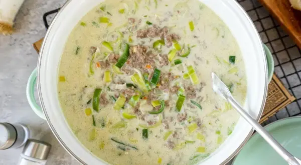 Cremige Lauchsuppe mit Hackfleisch in einem Topf, garniert mit Lauchringen.