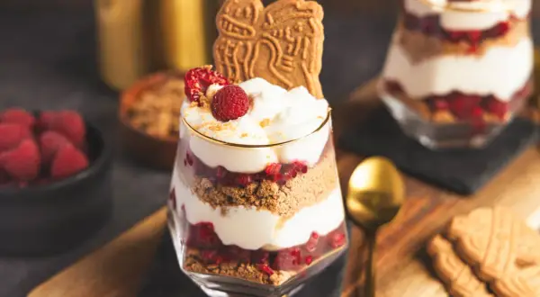 Spekulatius-Himbeer-Dessert im Glas mit Sahne und frischen Himbeeren, garniert mit Spekulatius.