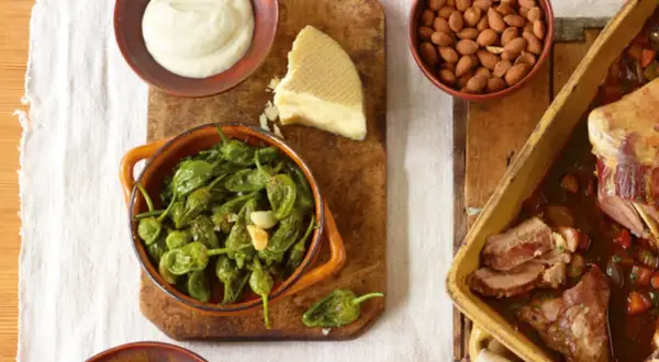 Tapas-Gerichte: Gebratene grüne Paprika, Käse, Mandeln und ein Braten.
