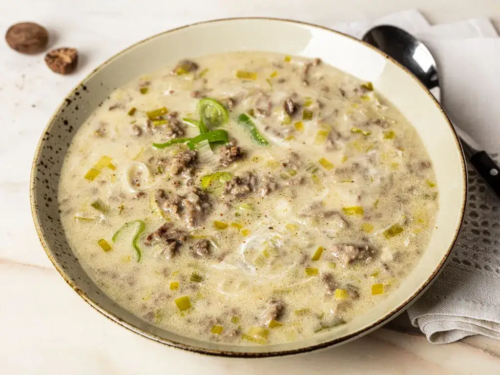 cremige Lauch K&auml;se Suppe mit Hackfleisch im tiefen Teller serviert