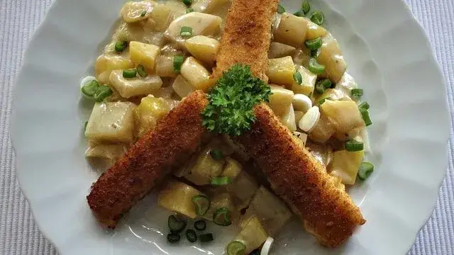 Frischer Kohlrabi und mehlig kochende Kartoffeln auf einem Holzbrett