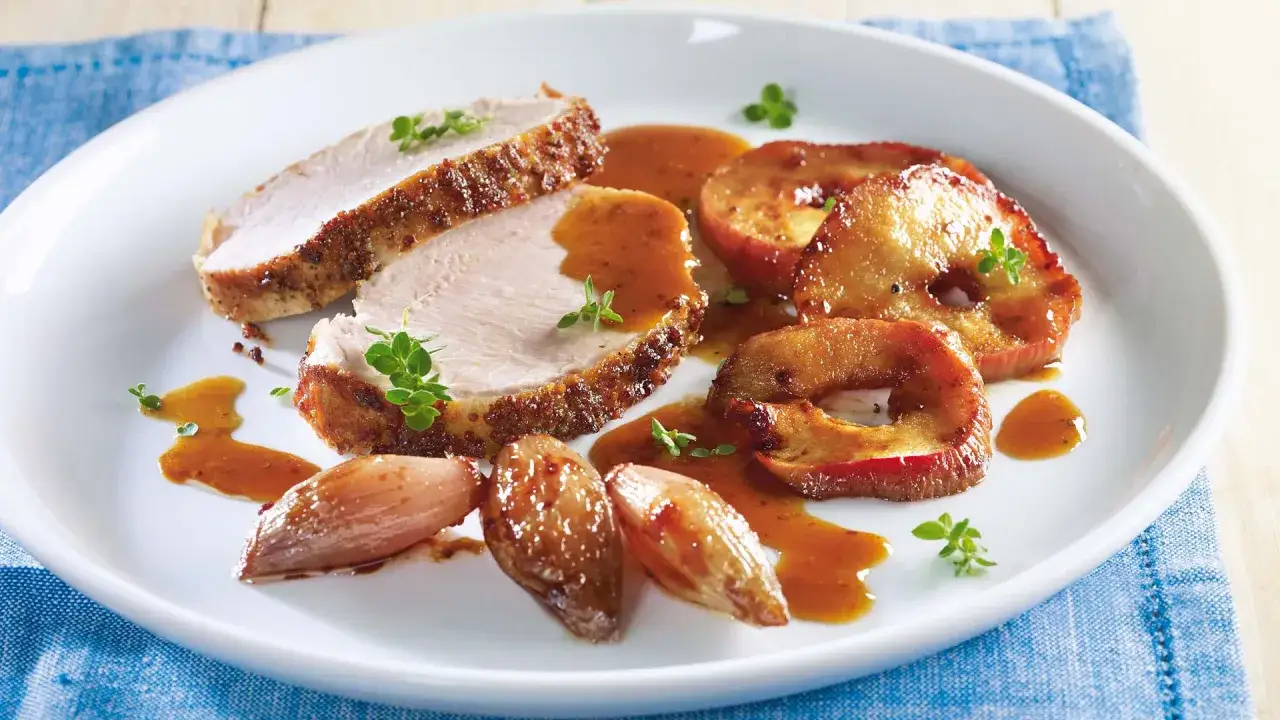 Schweinebraten mit Apfelf&uuml;llung und knuspriger Kruste auf einem Teller
