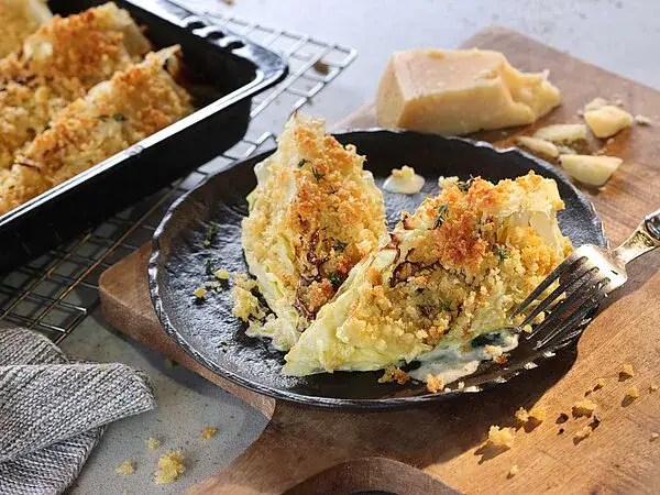 Gebackene Spitzkohlviertel mit Parmesan-Kr&auml;uter-Kruste auf einem Backblech