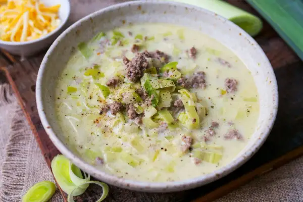 Cremige Lauchsuppe mit Hackfleisch und Käse, garniert mit Pfeffer.