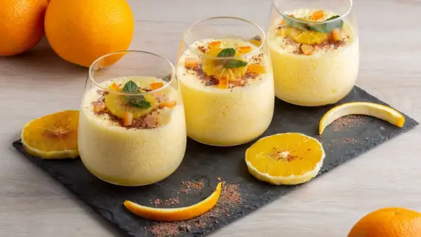 Orangendessert im Glas mit Orangenscheiben und Schokostreuseln.